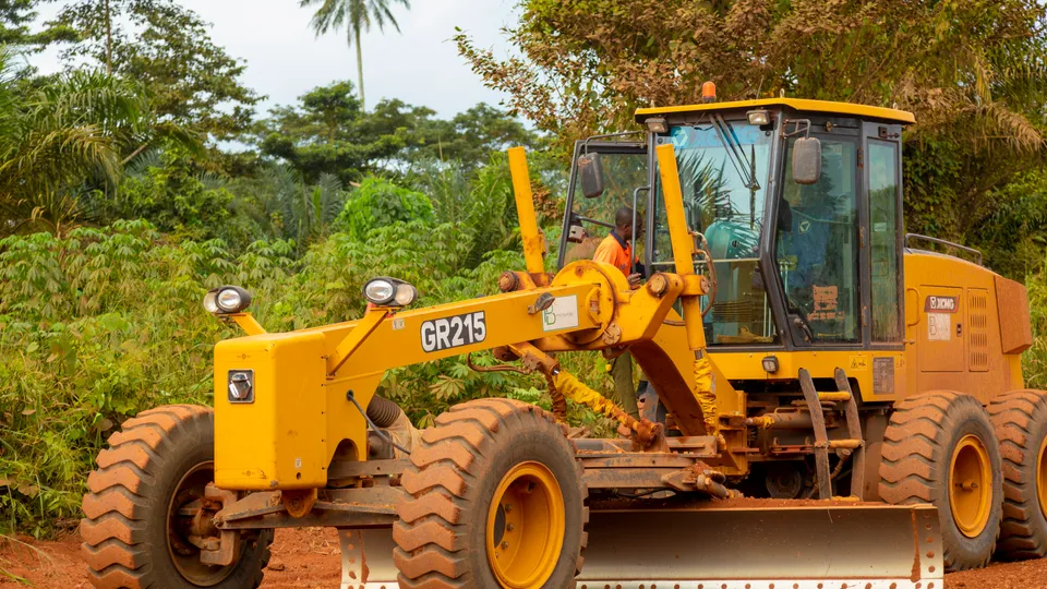 Motor grader reshaping a road surface