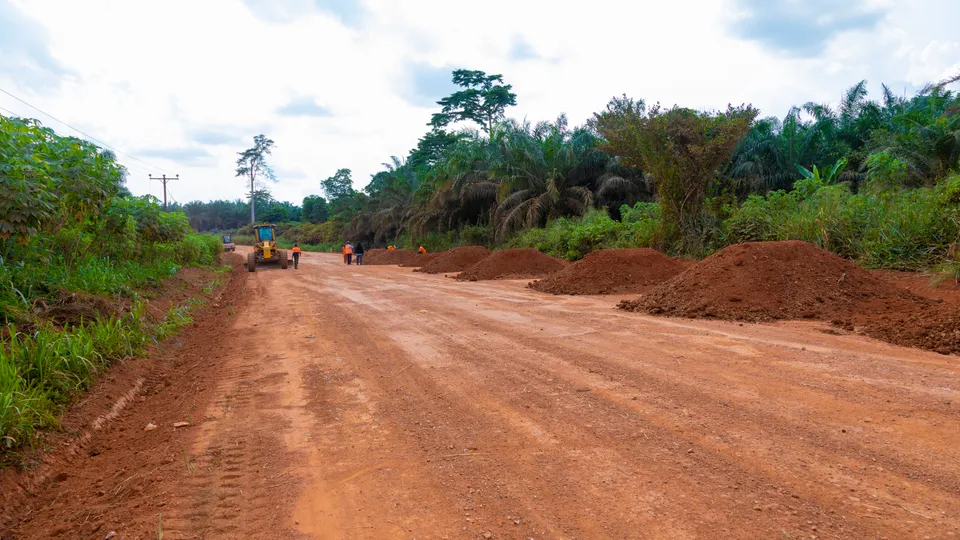 Road formation being reshaped, with laterite heaps along the edge