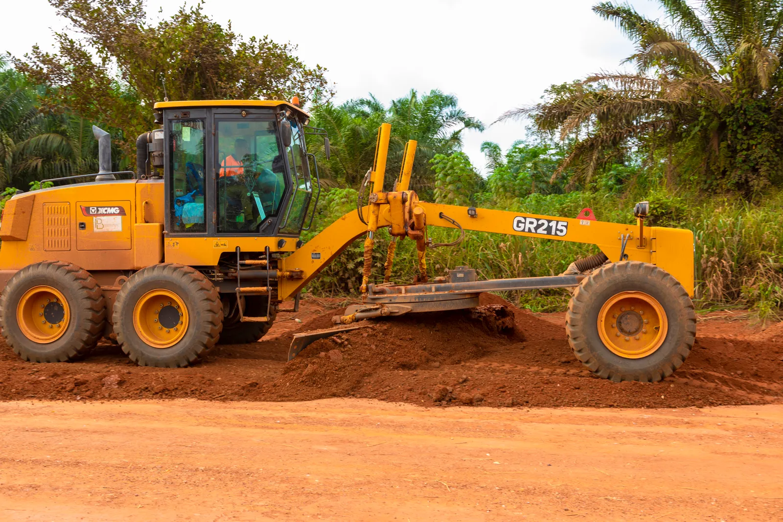 Motor grader spreading laterite on a road formation