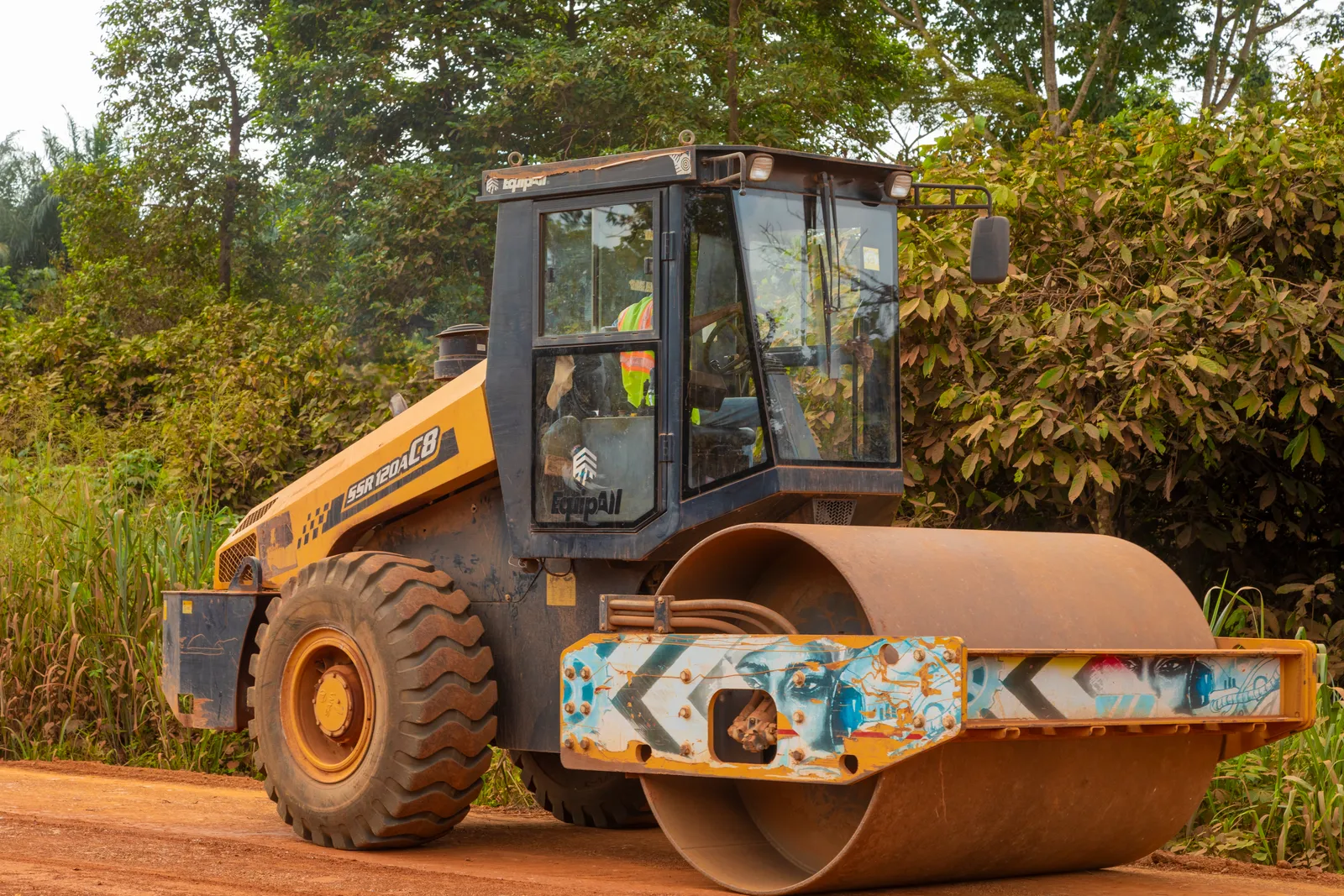 Vibratory roller compacting a laterite road layer