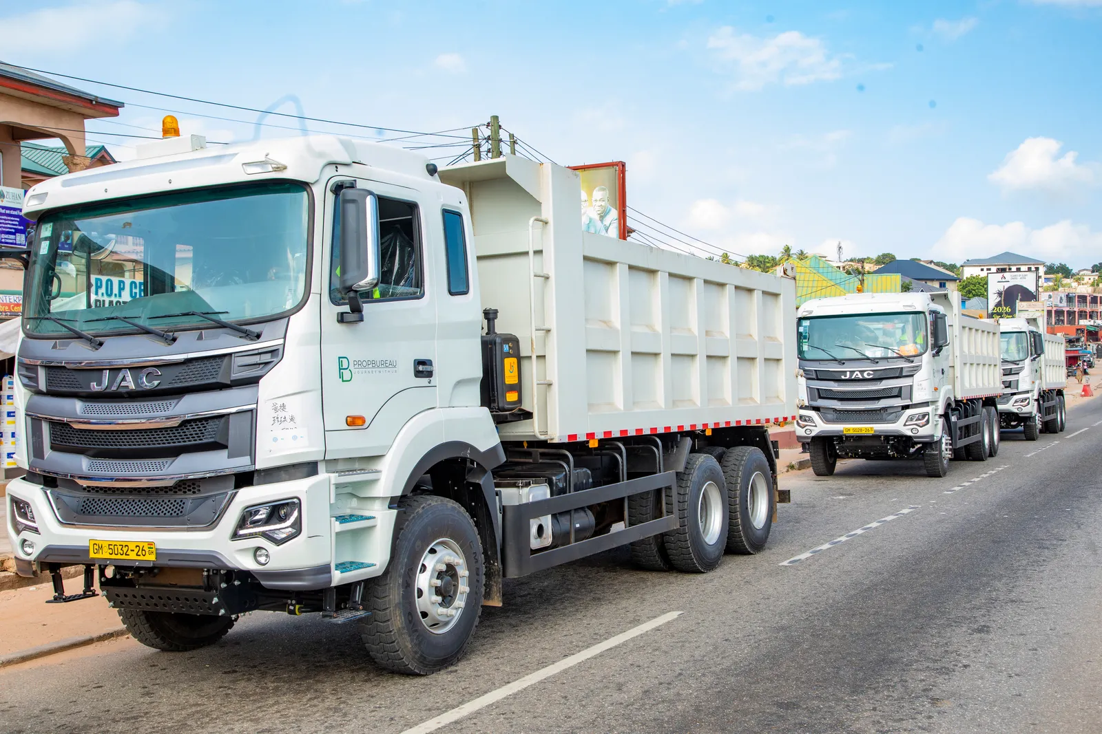 Propbureau tipper trucks travelling along a town road